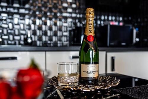 a bottle of wine and a glass on a counter at Apartament Glamour Vip in Ustka