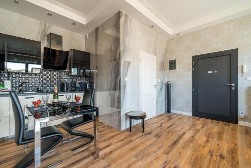 a kitchen with a black counter and a table at Apartament Glamour Vip in Ustka