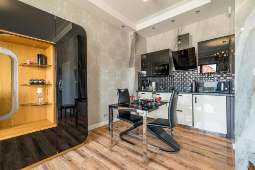 a kitchen and dining room with a table and chairs at Apartament Glamour Vip in Ustka