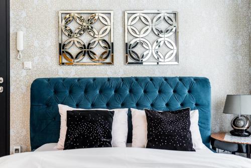 a bed with a blue headboard in a bedroom at Apartament Glamour Vip in Ustka
