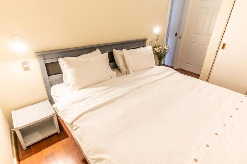 a large bed with white sheets and pillows at Montaña Blanca in Farellones