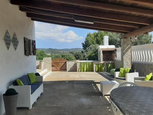 eine Terrasse mit Sofas, einem Tisch und einem Kamin in der Unterkunft A cà du Sepino a due passi dal mare in Carloforte