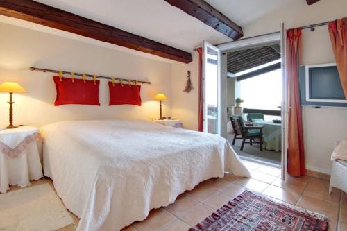 a bedroom with a large white bed and a patio at South of France Villa in Carros