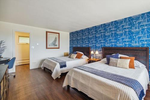um quarto de hotel com duas camas e uma parede azul em Breath taking Lake Views 5 min to DT Petoskey em Petoskey
