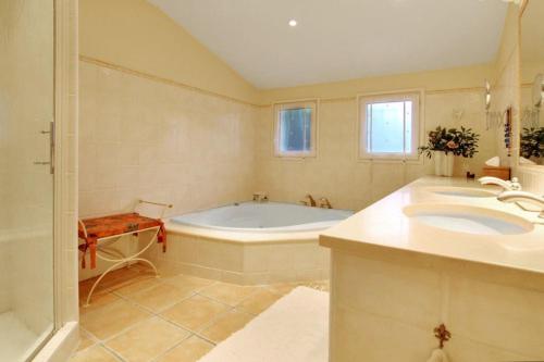 a bathroom with two sinks and a bath tub at South of France Villa in Carros
