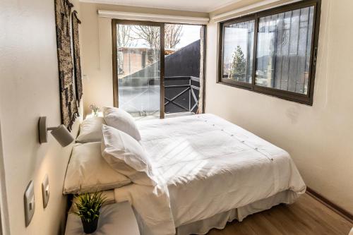 a bedroom with a white bed and a window at Montaña Blanca in Farellones