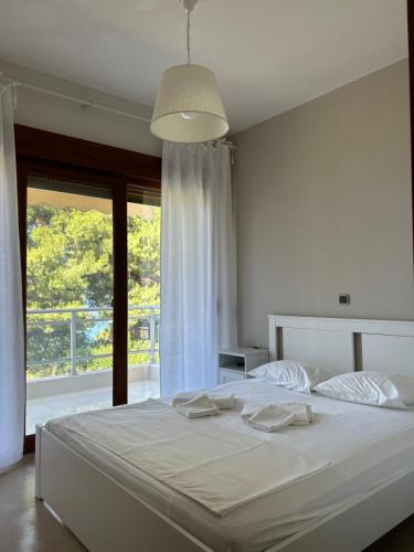 um quarto com uma grande cama branca e uma janela em Cute house by the sea em Kriopigi