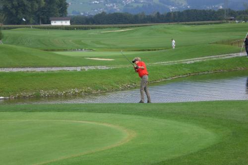 a man swinging a golf club on a golf course at Schäfle Landgasthof in Feldkirch