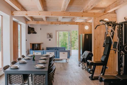 a living room with a table and a gym at Chalet HerMes arT in Idrija