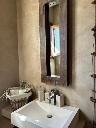 a bathroom with a white sink and a mirror at Cute house by the sea in Kriopigi