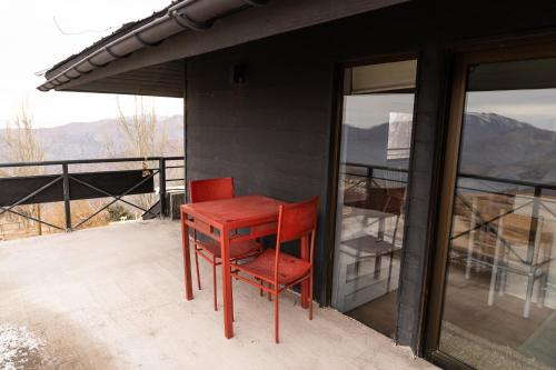 a red table and chair sitting on a balcony at Montaña Blanca in Farellones