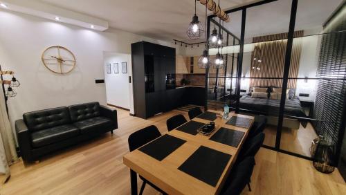 a living room with a table and a couch at Ukiel Park 21 by RENT4YOU in Olsztyn