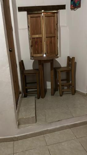 a table and two chairs and a cabinet in a room at Hotel del Pozo in San Sebastián del Oeste