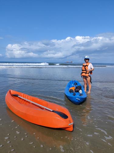 two people standing on the beach next to a kayak at Ayampe Guest House in Ayampe
