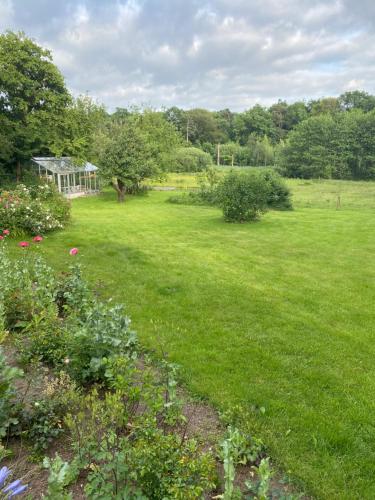 um campo de relva com um gazebo ao fundo em Hærvejshuset 