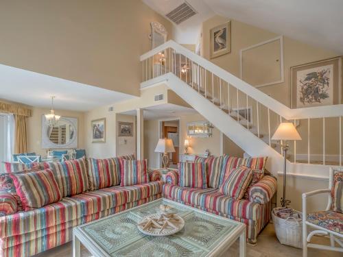 a living room with a couch and a staircase at 724 Spinnaker Beach Villa in Seabrook Island