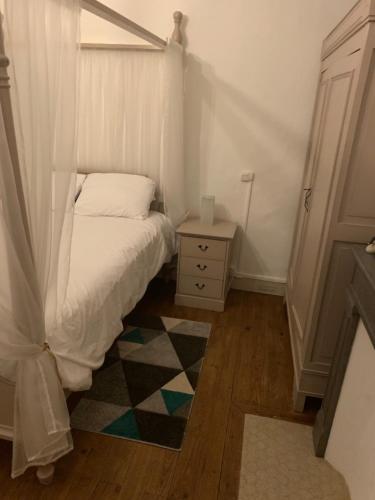 a small bedroom with a bed and a night stand at Lauberge de Nogaro in Caupenne-dʼArmagnac