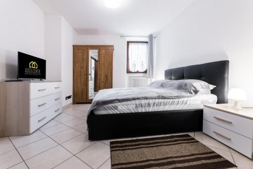 une chambre blanche avec un lit et une télévision dans l'établissement Aosta Centre Apartments - Croce di Città 88, à Aoste