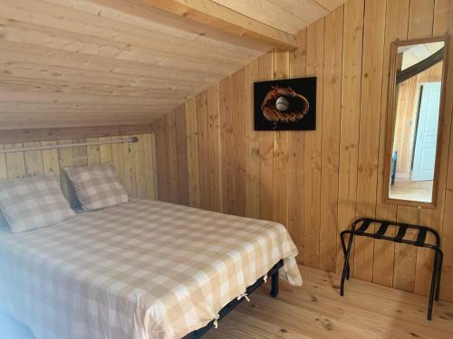 a bedroom with a bed in a wooden room at Lauberge de Nogaro in Caupenne-dʼArmagnac