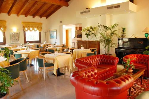 a restaurant with tables and chairs and red furniture at Hotel Luna in Vigonovo