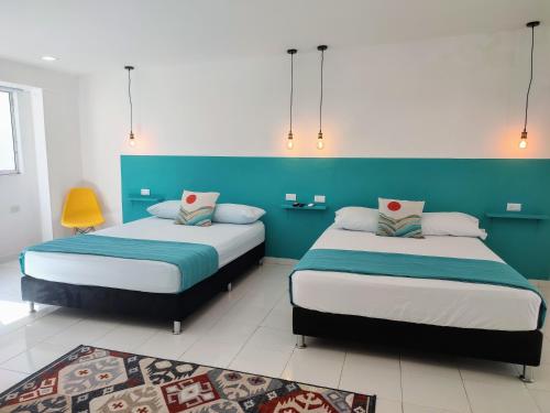 two beds in a room with blue and white at Bona Vida Hostel in Ríohacha