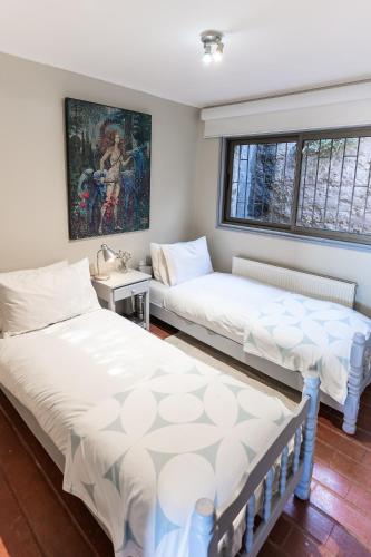 a room with two beds and a painting on the wall at Montaña Blanca in Farellones