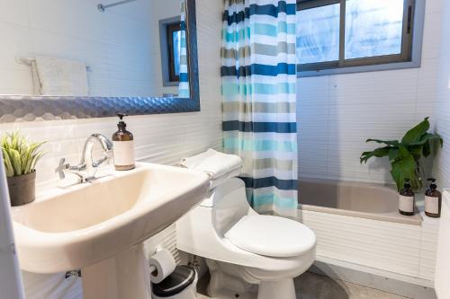 a bathroom with a sink and a toilet and a tub at Montaña Blanca in Farellones