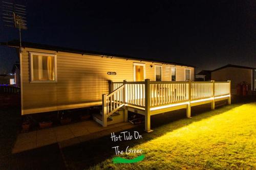 a house with a porch and a deck at night at Home from Home Lettings at Tattershall Lakes - The Green in Tattershall