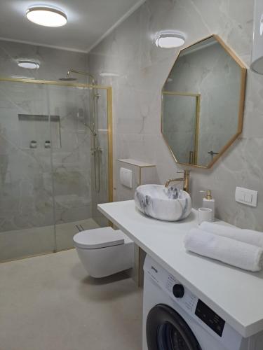 a bathroom with a sink and a toilet and a mirror at Bella Luxury Apartment in Sali