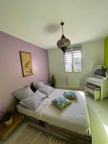 a bedroom with a large bed and a chandelier at Chambre d’hôtes Soleil Levant in Six-Fours-les-Plages