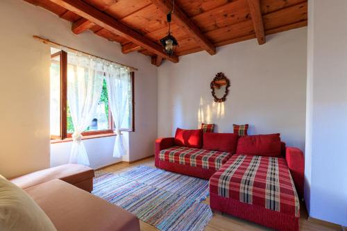 a living room with a red couch and a window at Aranyrózsa Porta in Balatonszárszó
