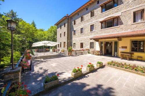 a courtyard in front of a building with flowers at Casa PerFerie “PASTOR ANGELICUS” in La Verna