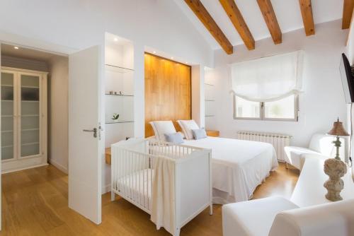 a white bedroom with two beds and a couch at Casa Azahar y Casa Buganvilla in Gandía