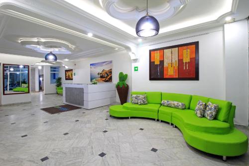 um sofá verde no meio de um quarto em Hotel Abi Inn By GEH Suites em Cartagena de Indias