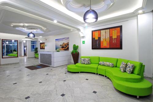 a green couch in the middle of a room at Hotel Abi Inn By GEH Suites in Cartagena de Indias