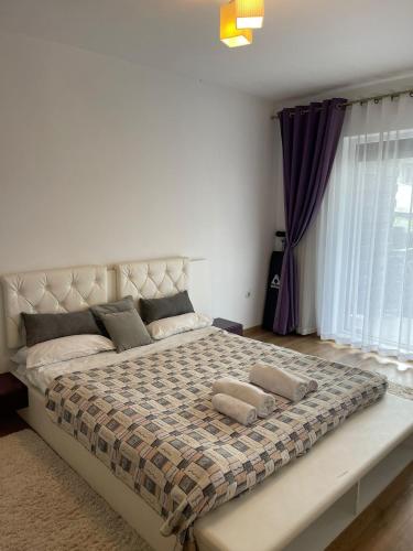 a bedroom with a large bed with two pillows on it at YamaLuxe Apartments - Home-Like Apartment (in Buna Ziua) in Cluj-Napoca