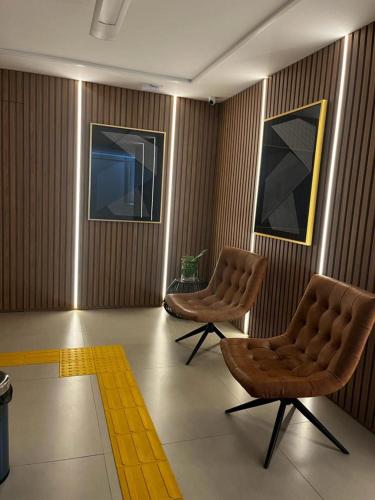 a room with two chairs and a yellow rug at Studio no West Fit Mossoró Nova Betania in Mossoró