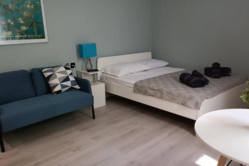een slaapkamer met een bed en een blauwe bank bij I5 studio in Ioannina