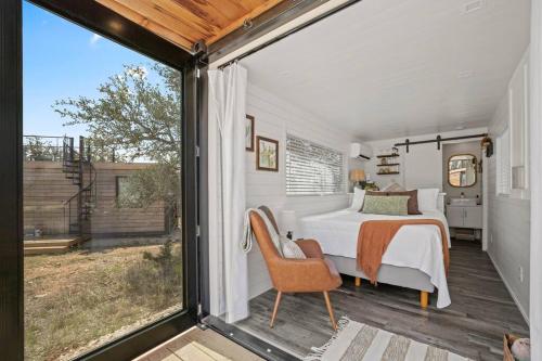 a bedroom with a bed and a large window at New The Saguaro-Tiny Shipping Container Home in Fredericksburg