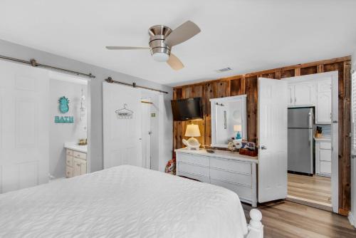 Un dormitorio con una cama blanca y una cocina. en 200 Steps to the Beach, en Destin