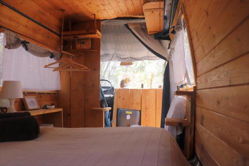 a bedroom with a bed and a wooden wall at Soul Farm Algarve - Glamping & Farm Houses in Aljezur