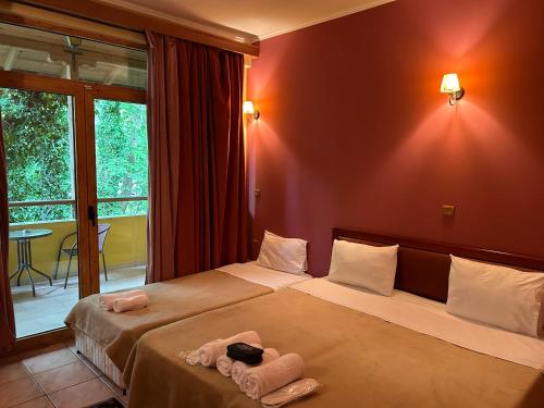 Habitación de hotel con 2 camas y toallas. en Margaret's Island Hotel en Naousa Imathias