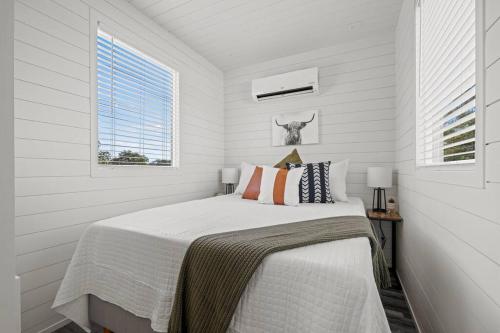 a white bedroom with a bed and a window at New! The Texas Longhorn-Luxury Container Home in Fredericksburg