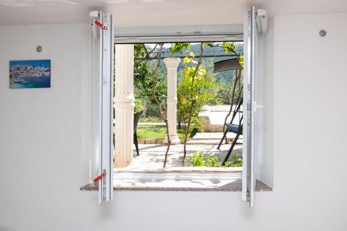 eine offene Tür mit Gartenblick in der Unterkunft Apartments Jadranka in Grebaštica