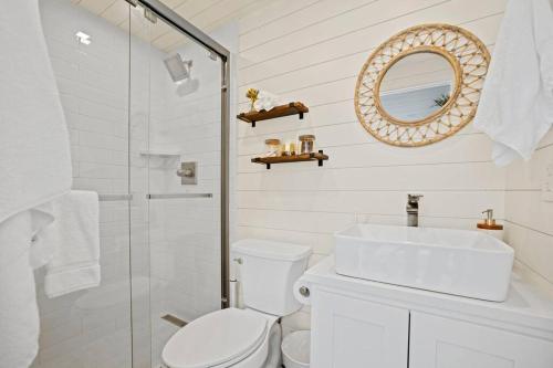 a bathroom with a toilet and a sink and a mirror at New The Sunset Luxury Container Home in Fredericksburg