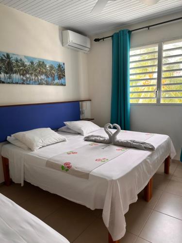 a bedroom with two beds and a window at Hôtel DOUCE VAGUE in Sainte-Luce