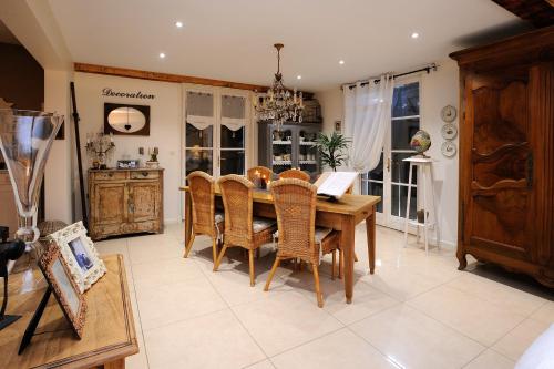 une salle à manger avec une table et des chaises en bois dans l'établissement La Brocantine, à Corcelles-en-Beaujolais