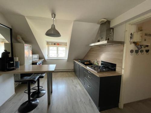 une cuisine avec une table et un comptoir dans l'établissement Charmant F3 à Gérardmer Centre, à Gérardmer
