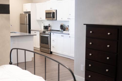 uma cozinha com armários brancos e um forno com placa de fogão em New Spacious Studio Suite with Mountain Views em Kamloops