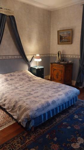 a bedroom with a bed and a table with a lamp at La chambre bleue in Bussang